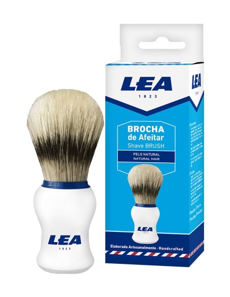 Brocha de afeitar LEA de pelo natural junto a su caja de embalaje azul y blanca con el texto fabricada artesanalmente.