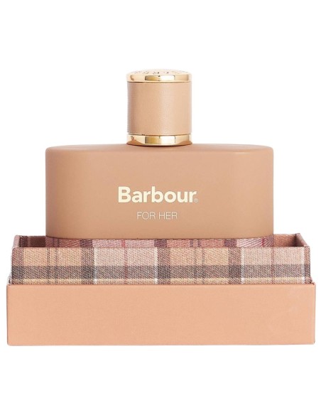 Perfume femenino en frasco de tono nude con tapón dorado sobre su estuche con diseño de cuadros.